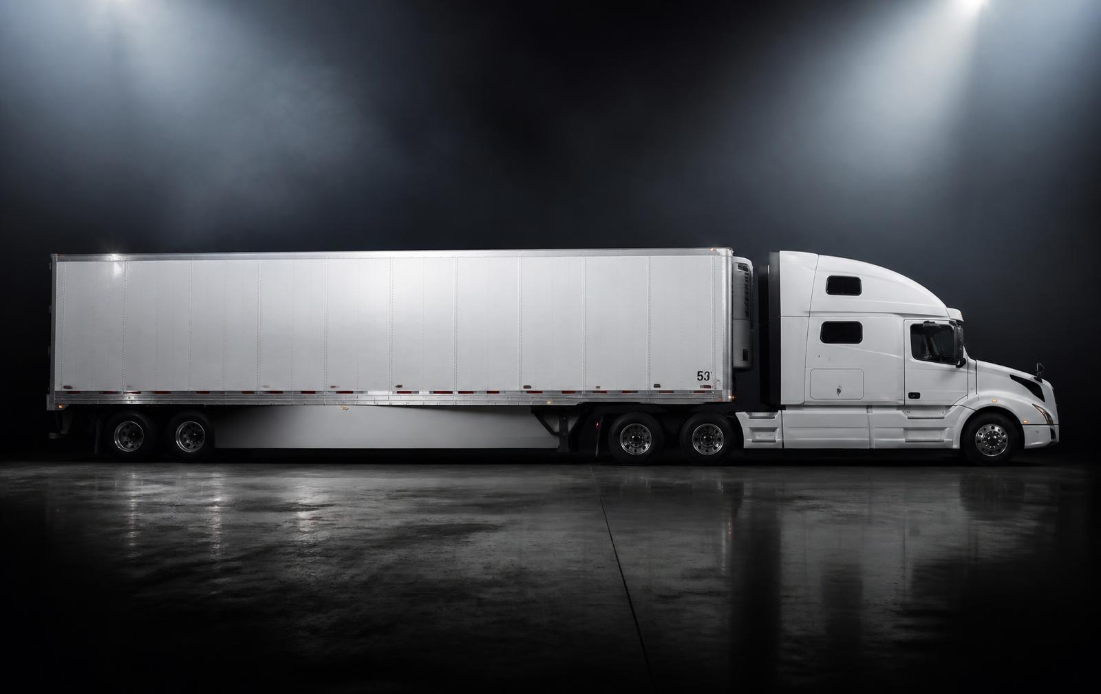 Modern sleeper tractor coupled to a clean 53-foot dry van trailer under soft studio lighting